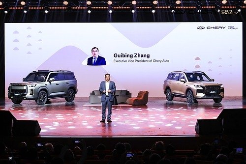 Chery executive VP Guibing Zhang on stage at CHERY Brand Night in Wuhu with the all-new TIGGO7 and TIGGOX7 behind him