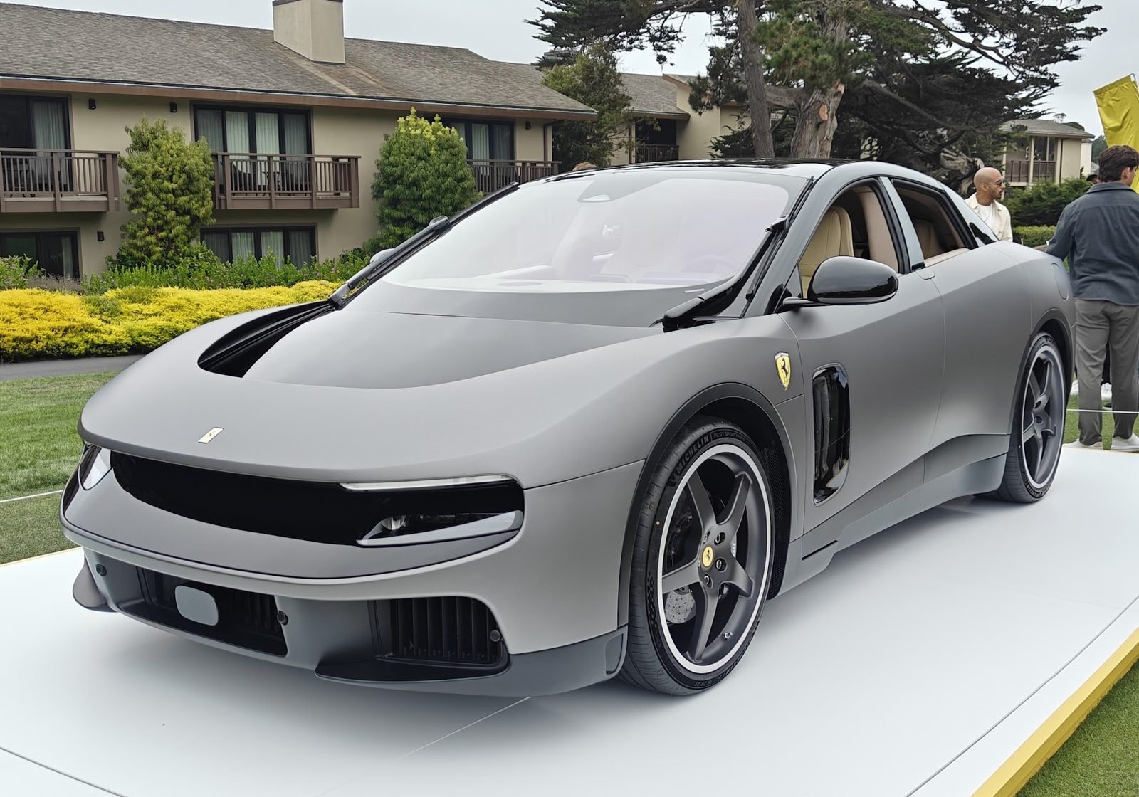 Ferrari Luce electric car in matte gray, front three-quarter view, photographed at Pebble Beach in 2026