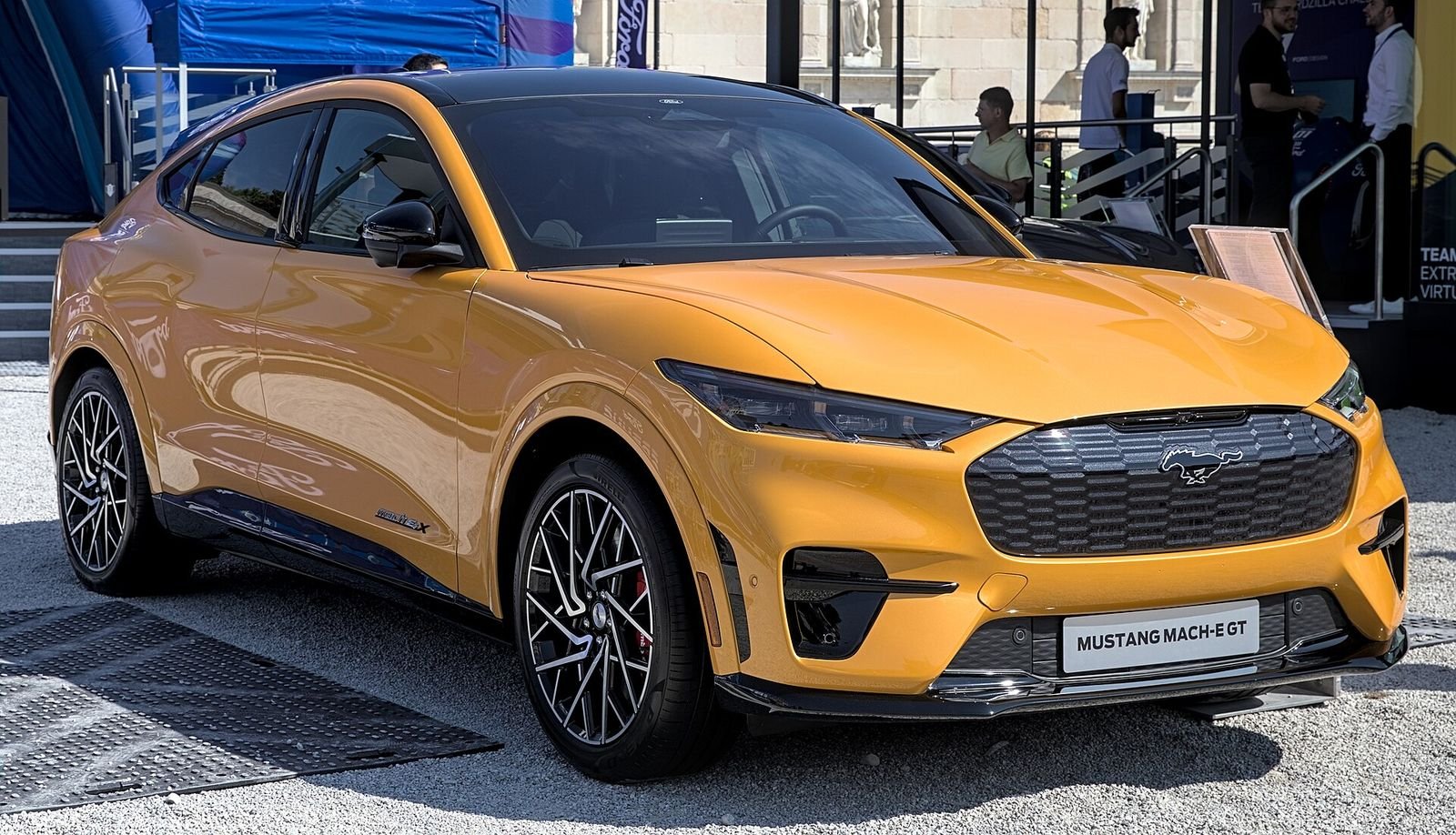 2027 Ford Mustang Mach-E GT in orange — the GT drops $2,400 for 2027