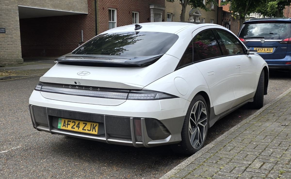 White Hyundai Ioniq 6 rear three-quarter view showing the full-width light bar