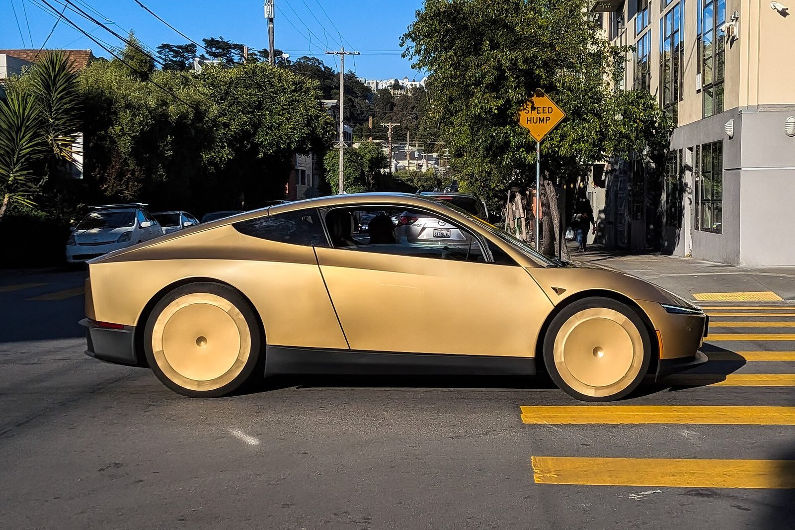 A gold Tesla Cybercab robotaxi on a San Francisco street — the purpose-built two-seater now operating in Austin