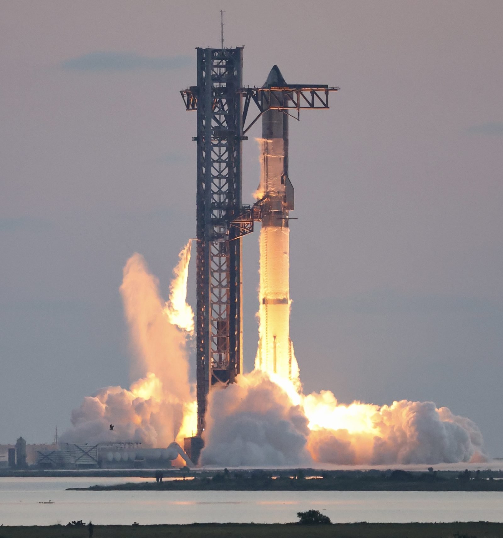 SpaceX Starship igniting during a test flight — SpaceX is the stronger half of any potential merger