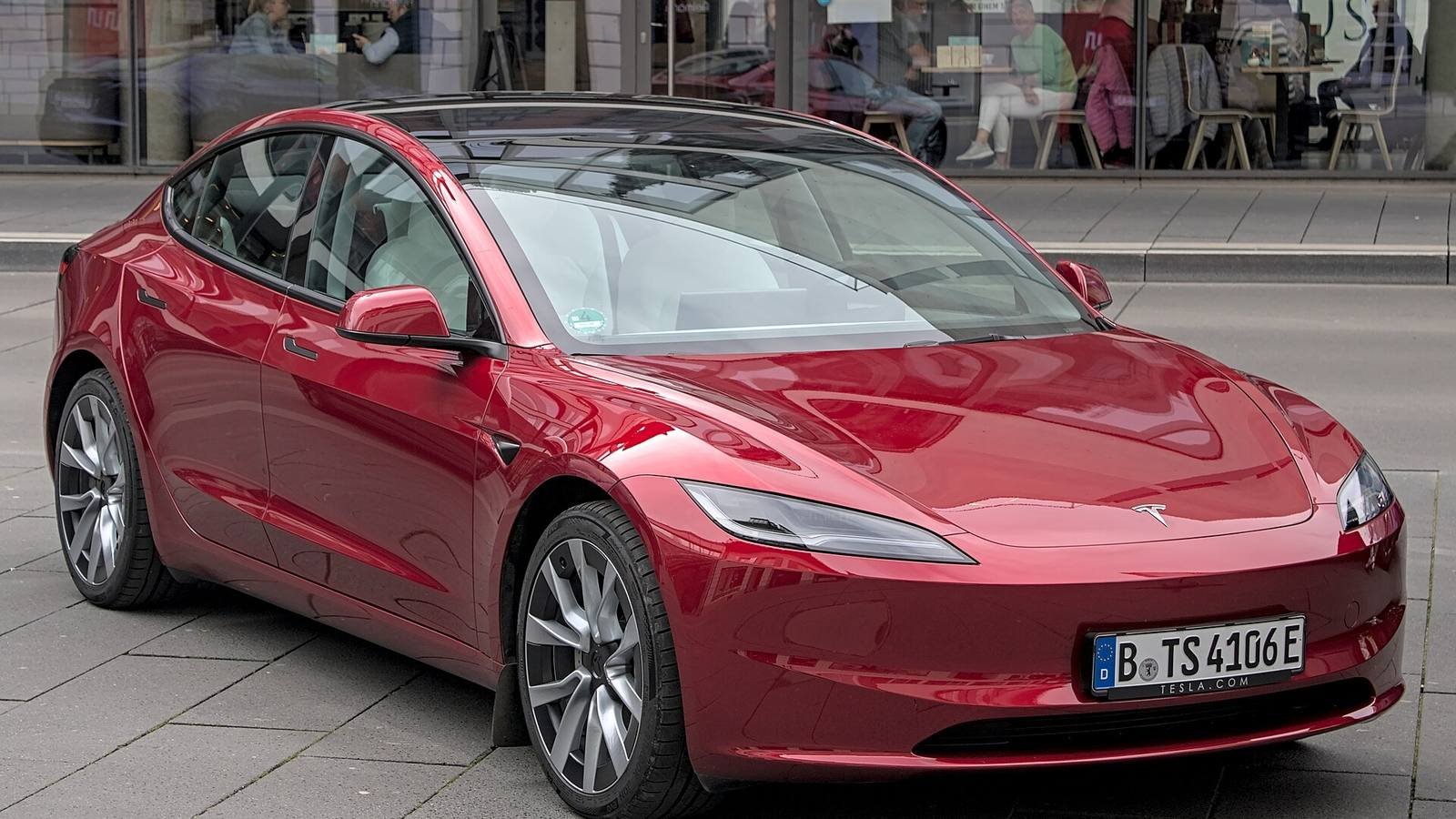 Red Tesla Model 3 parked on a city street