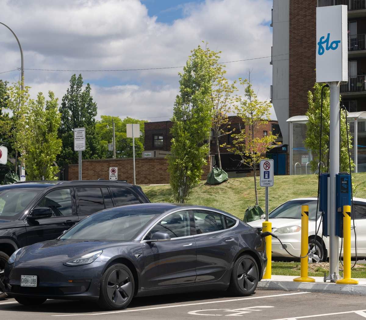 Blue Tesla Model 3 plugged into a charger