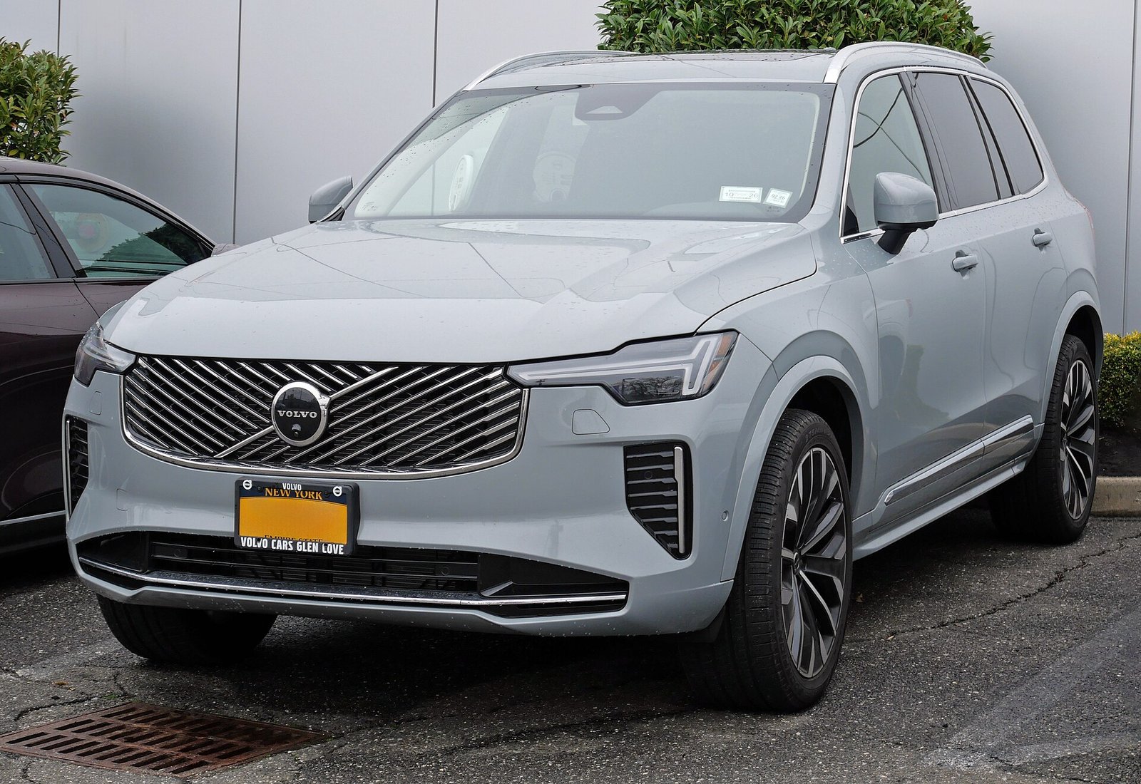 Silver 2026 Volvo XC90 plug-in hybrid front three-quarter view showing the facelifted diagonal grille